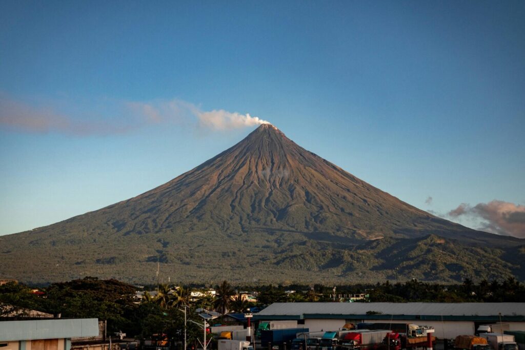 Arenal Volcano with smoke rising, viewed from nearby town.