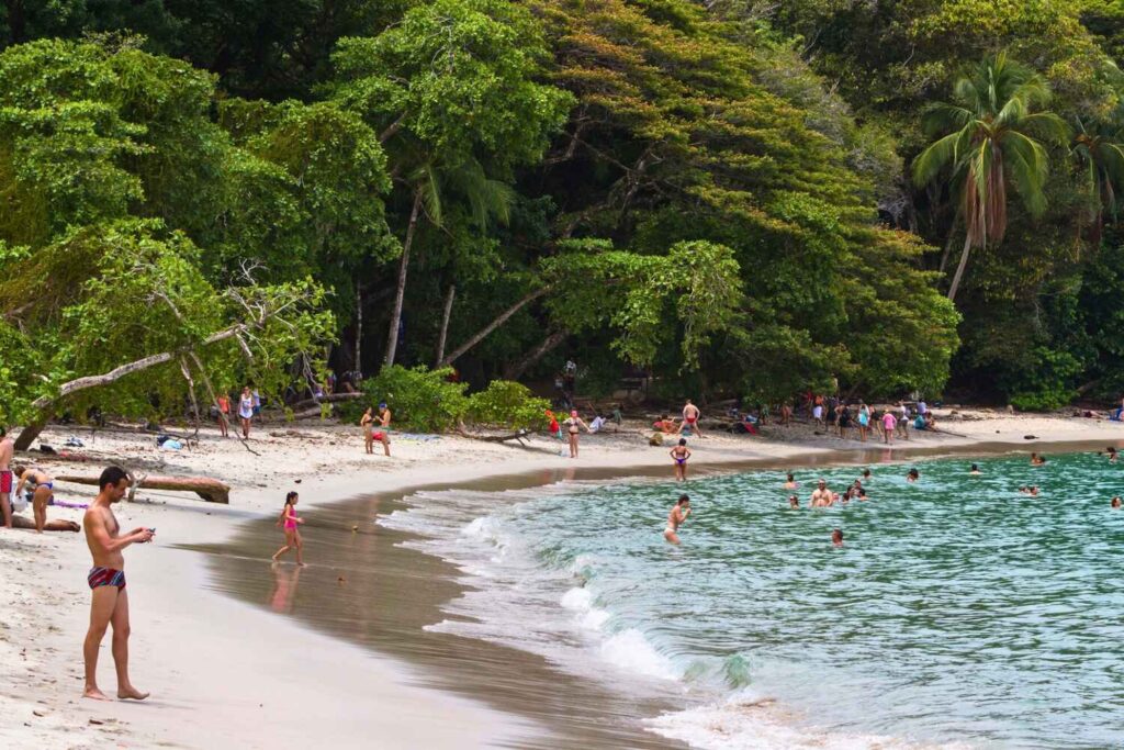 People swimming and relaxing on a tropical beach in Manuel Antonio Costa Rica