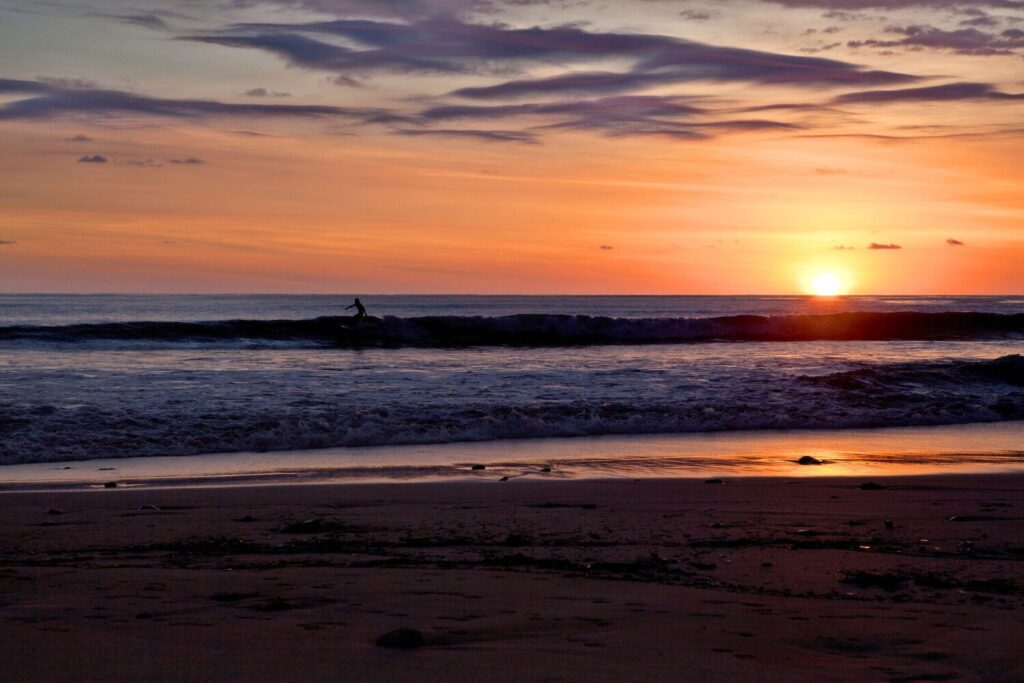 Surfer catching waves during sunset in Costa Rica