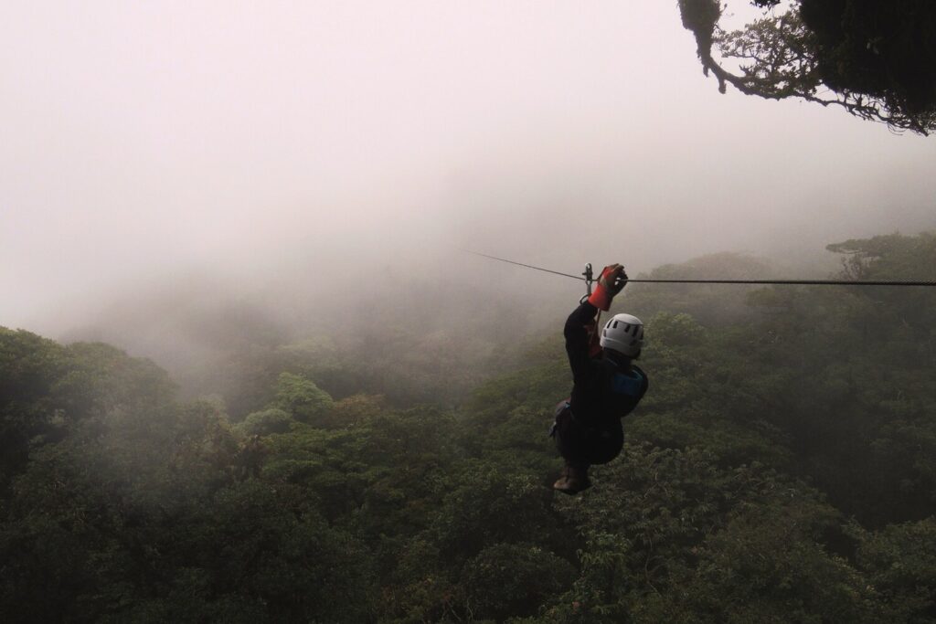 Ziplining through misty rainforest canopy