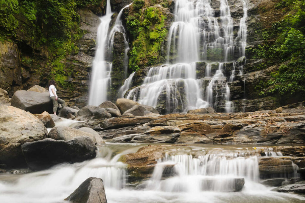 A mature woman is enjoying the Nauyuca Waterfall (Santo Cristo Waterfall) near Dominical, Costa Rica