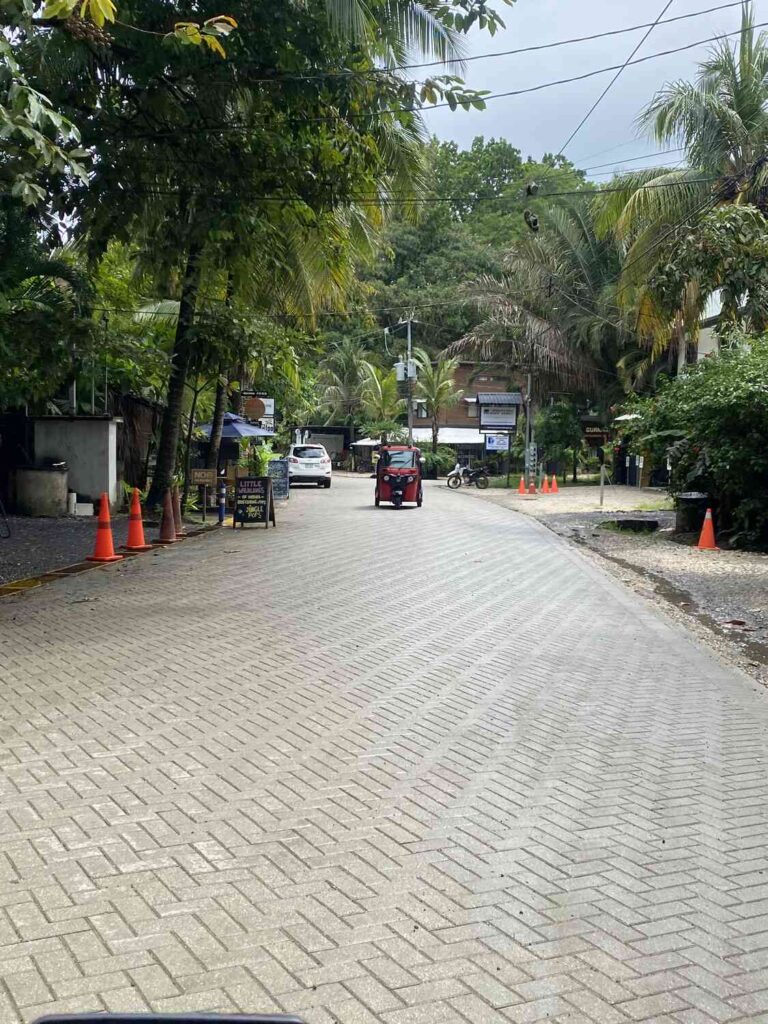 Tuk-tuk driving down a paved street in central Nosara