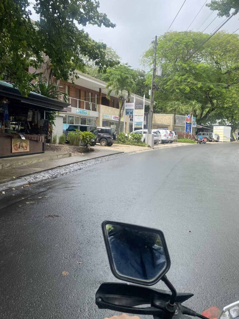 View of Nosara’s main street with shops and parked cars