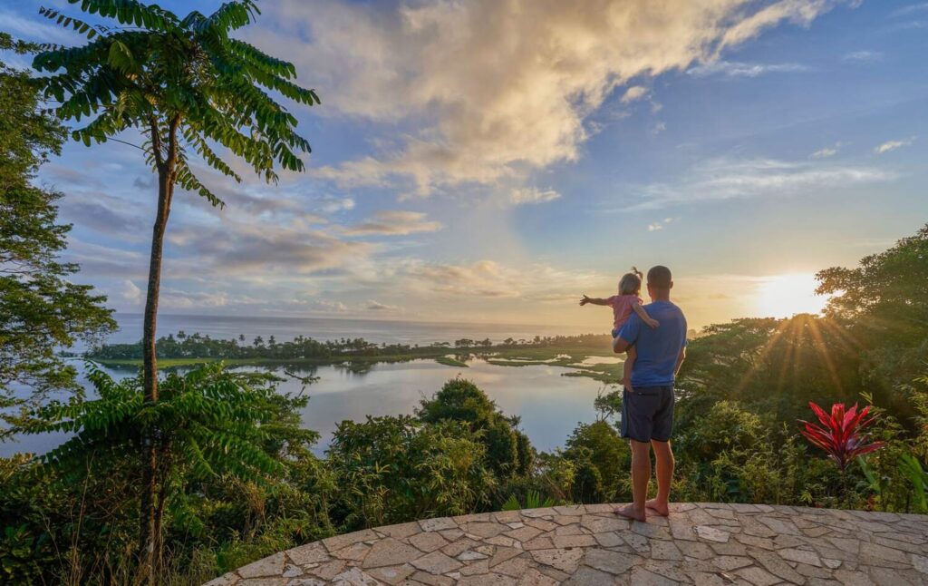 Man holding a child overlooking sunset and lagoon in Manuel Antonio